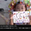 キッズモデルがありがとうと書かれたイラストを持っている