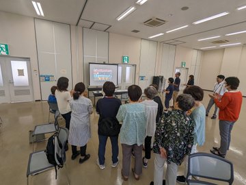 10人ほどの参加者が画面を囲んで太鼓の達人を楽しむ様子