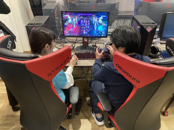 視覚障害を持つプレイヤーともう一人のプレイヤーが隣り合って座り、ゲームを操作している。