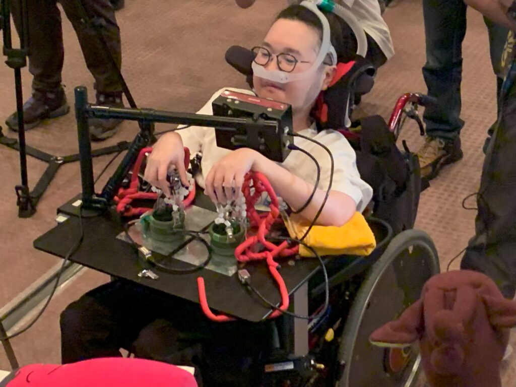 車椅子に設置した自作のコントローラーを操作する畠山