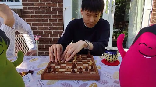 ましろがチェスをプレイしている様子。チェスボードのマスに段差がついており、それを両手の指で確認している。