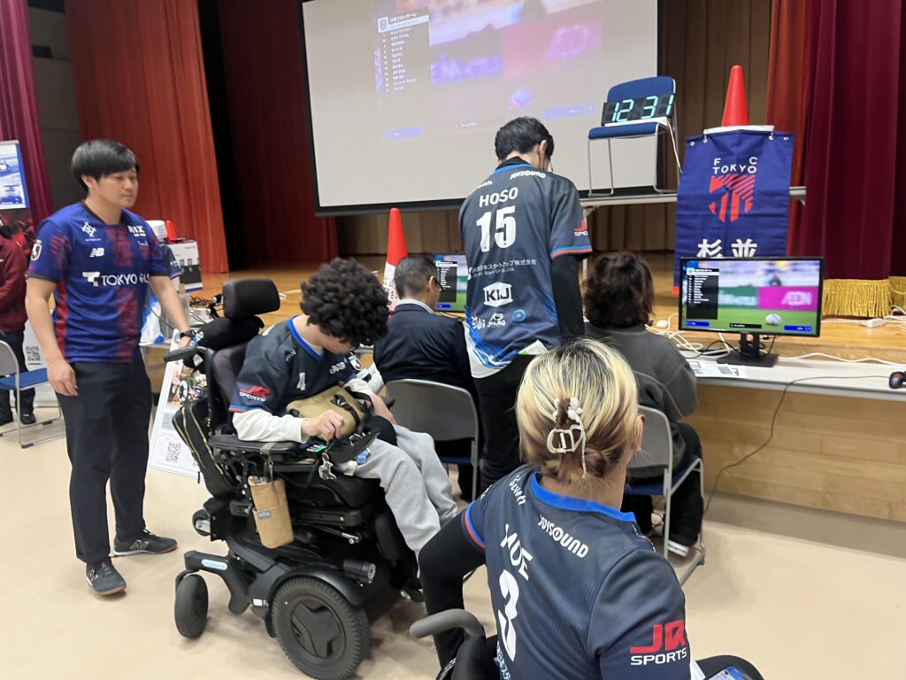 「ふれあいスポ・レク」のeスポーツコーナーでePARAユナイテッドと「FC24」をプレイする様子。車椅子ユーザーのプレイヤーと一般参加者が一緒にプレイしている。