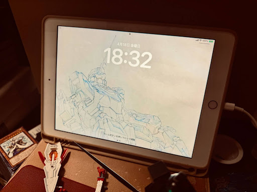 立てかけられたiPadの写真。ロック画面の壁紙はガンダムの線画。