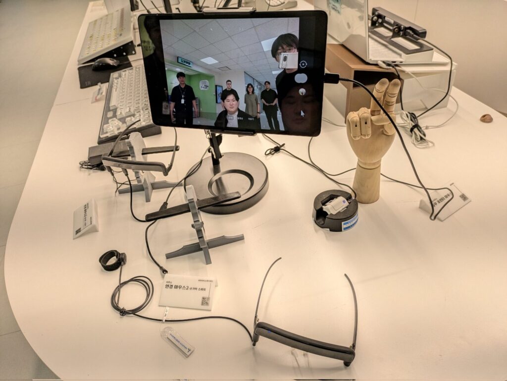 タブレット、キーボード、メガネ型デバイスなどが机の上に並べられている様子
