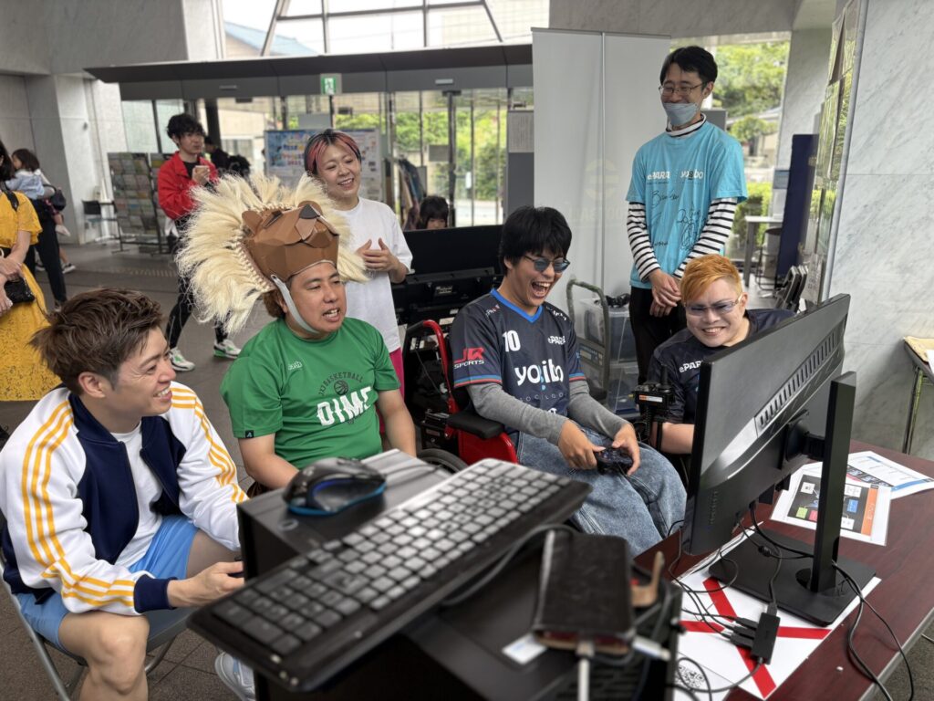 大西ライオンさんとEverybodyのタクトOK!!さんが、車椅子eサッカーチームの羽飛や神威龍牙と「eFOOTBALL™」で4人共闘プレーを楽しむ様子。Everybodyかわなみchoy?さんも楽しそうに観戦しています。