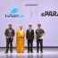 Hawk Gaming Groupとイーパラのロゴが映し出されたステージで覚書を手に持ち記念写真に写るePARA加藤ら4人