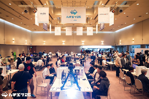 広い会場内で多くの人がゲームをしている様子