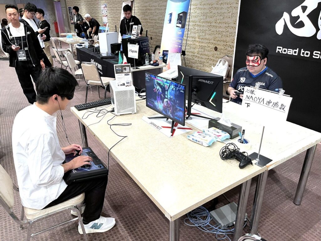 NAOYAさんと、アイマスクをした参加者が対戦している様子