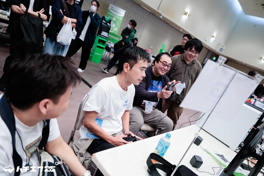 真剣な顔でプレイするさなけんさんと、楽しそうに笑う対戦相手の二人の様子