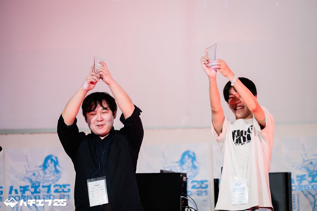 トロフィーを両手で掲げてうれしそうな優勝者の二人