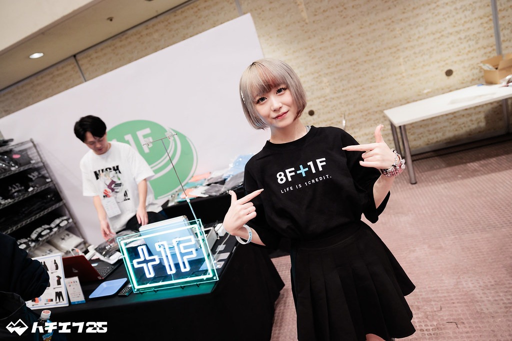 黒地に「8F+1F」と書かれた、プラスワンフレームとハチエフのコラボTシャツを着たべてぃ氏の写真