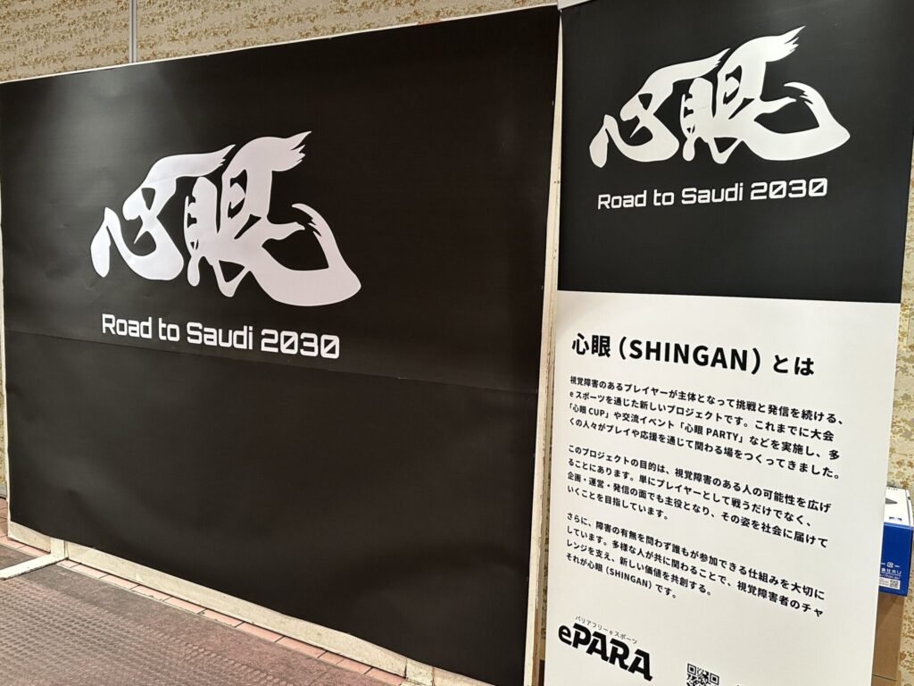 黒字に白文字で「心眼」大きく書かた下に「Road to Saudi 2030」と書かれた特大パネルと、心眼プロジェクトの説明文の書かれたパネルの写真