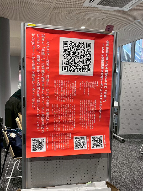 多数の文字と4つのQRコードが表示されている大型ポスター。タイトルは、音声表現を使った不明瞭なものの「共鳴化」