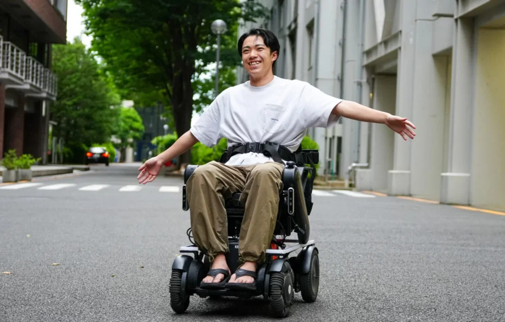 半自動運転車いす Feelingに乗った男性が両手を広げている写真