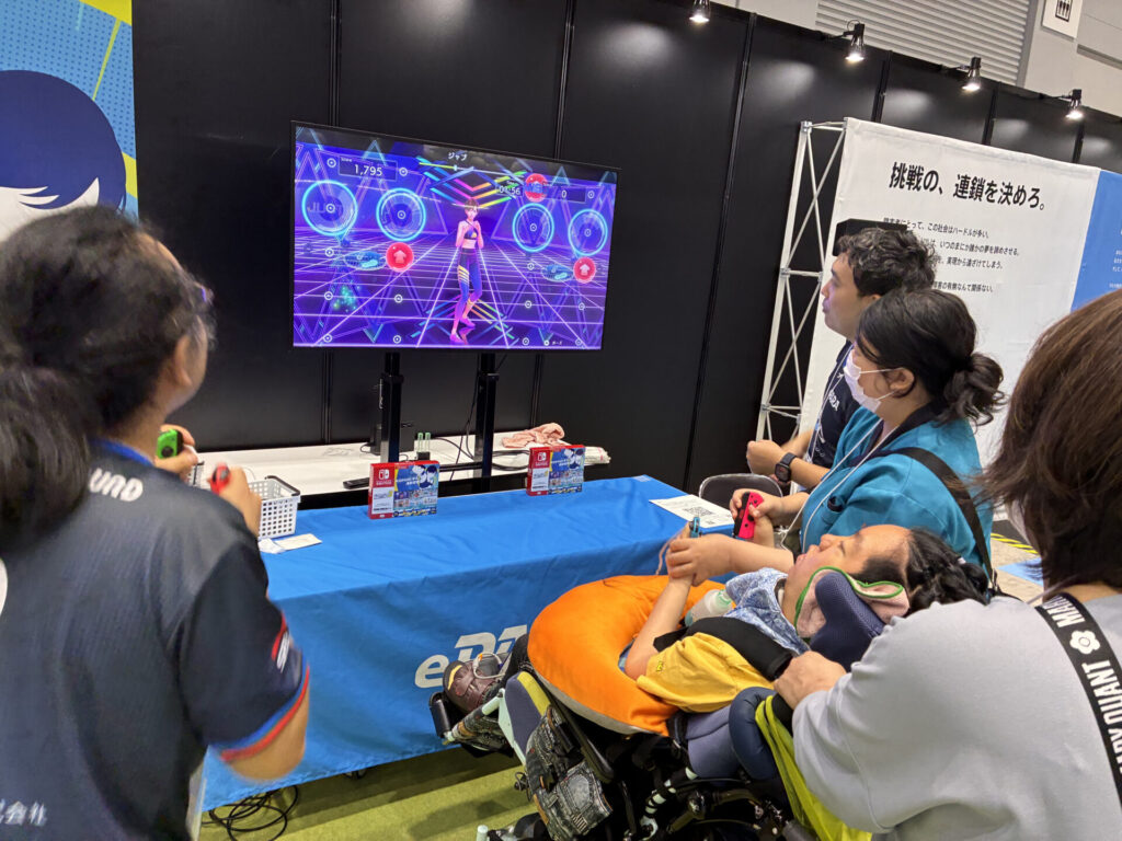 会場に設置された「Fit Boxing3」体験コーナーで車椅子の参加者の方と同行されている方々がプレイする様子