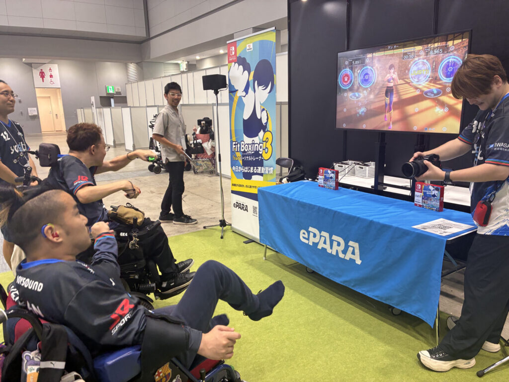 会場に設置された「Fit Boxing3」体験コーナーで二人の車椅子メンバーがプレイする様子