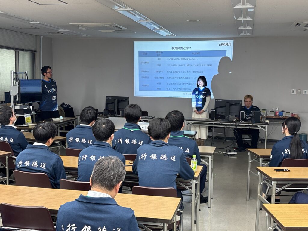 「視覚障害とは？」というスライドを見せながら参加者に向かって話す美里