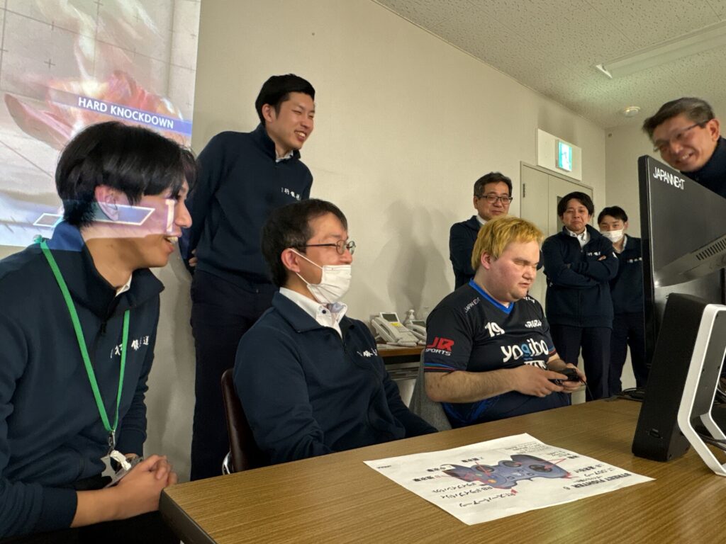 並んでゲームをプレイする直也と参加者