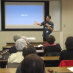 イベントでマイクを持って話す加藤