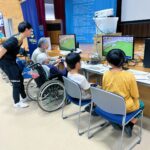 高齢者や子どもがサッカーゲームをプレイする様子