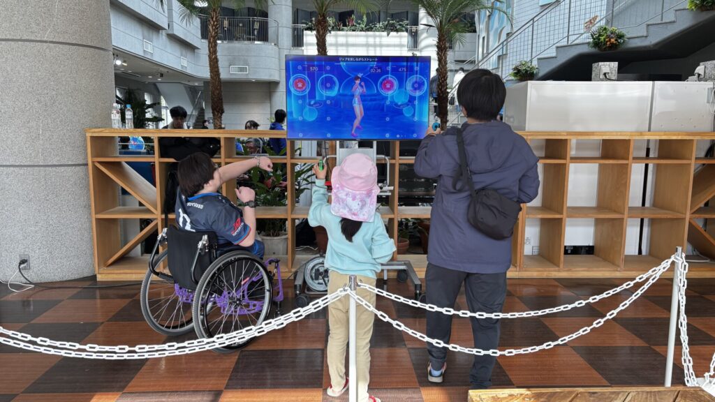 フィットボクシングを一緒にプレイする親子と神威龍牙さん