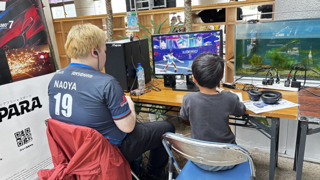 イヤホンをしてストリートファイター6で子どもと対戦する直也