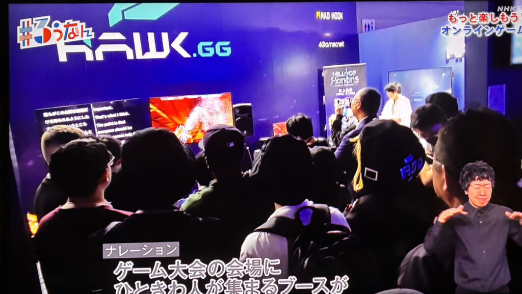 Hawk GG &times; ePARA バリアフリーeスポーツプログラム @EVOJ26内で、パラeスポーツプレイヤーが来場者と対戦する企画に人だかりができる様子。
