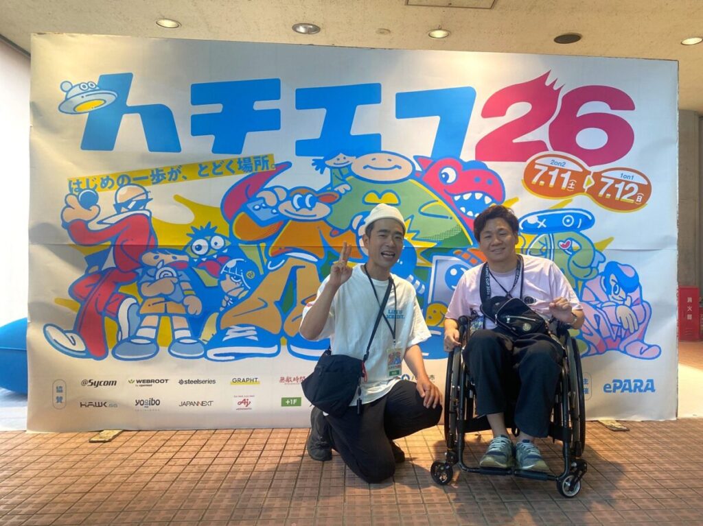 筆者たなけんとゆうたろうがハチエフキービジュアルの前に座って撮影したツーショット。