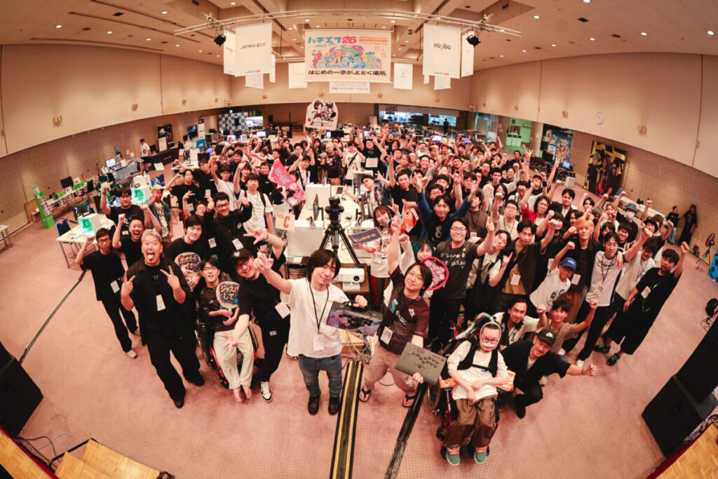 集合写真。ざっと120人ほどの参加者・スタッフが拳を上げて写っている。