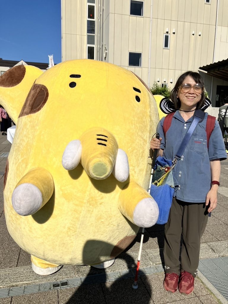 笑顔で立つ長谷川広美さん